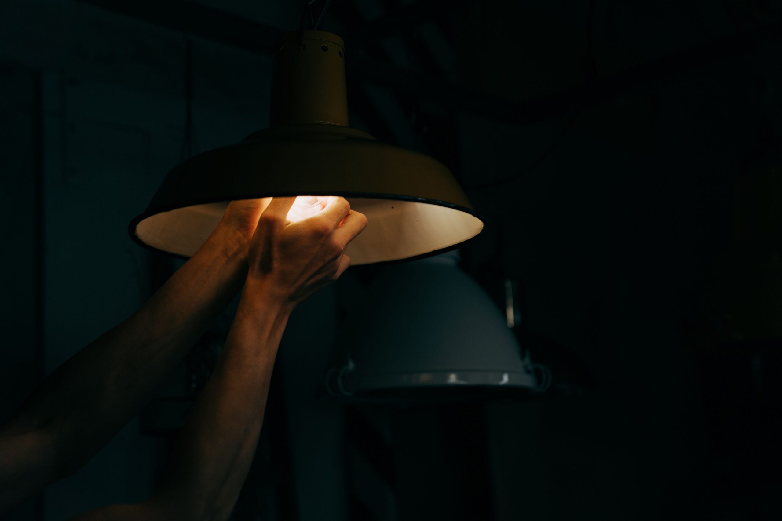 Electrician replacing a hard-to-reach commercial light fixture
